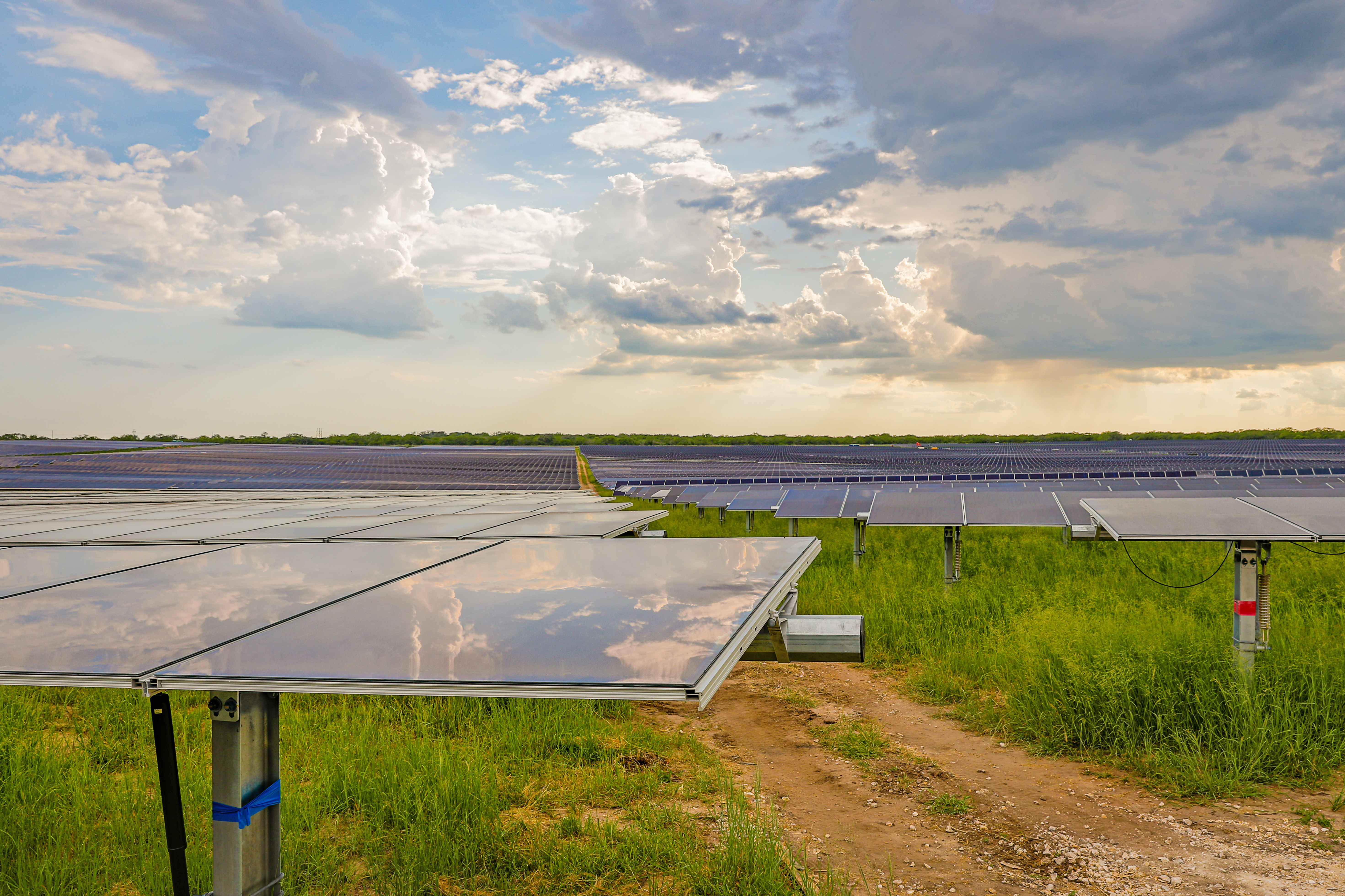 view of installed solar panels reflecting clouds in sky