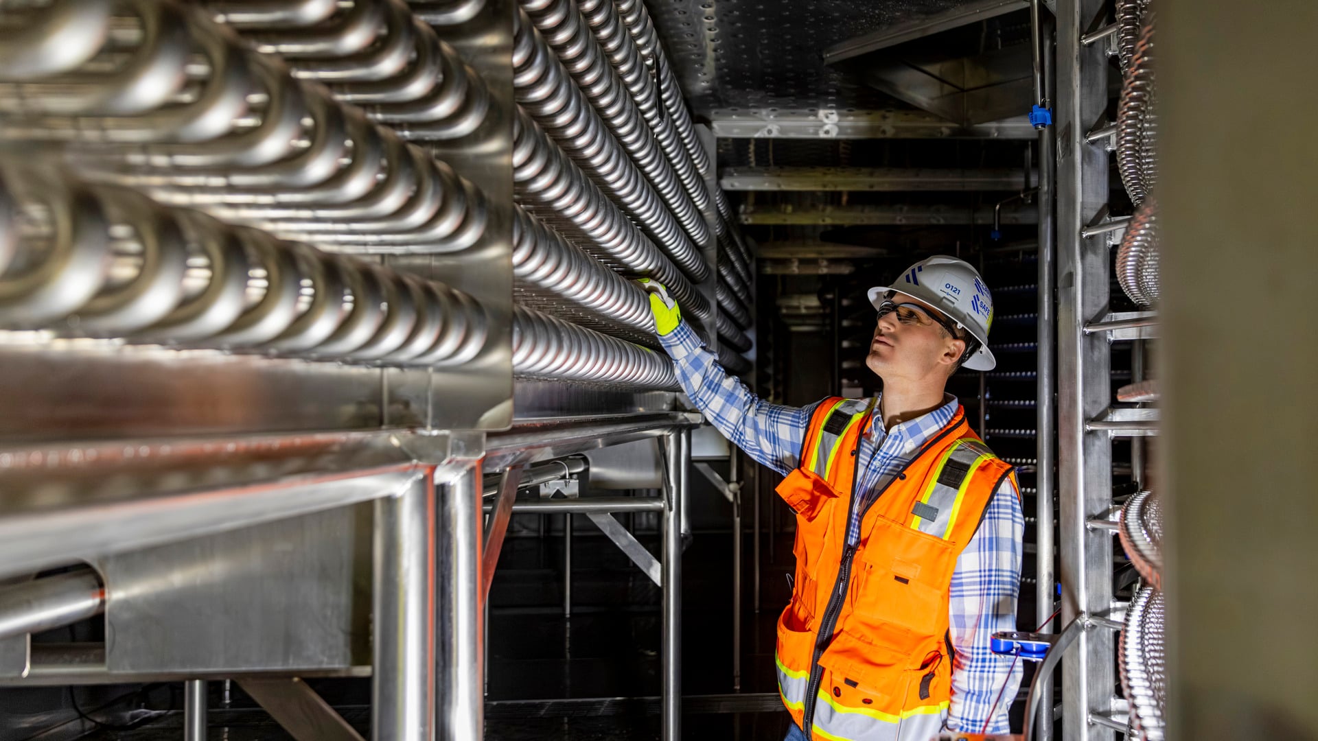 Engineer inspecting refrigeration equipment in a plant