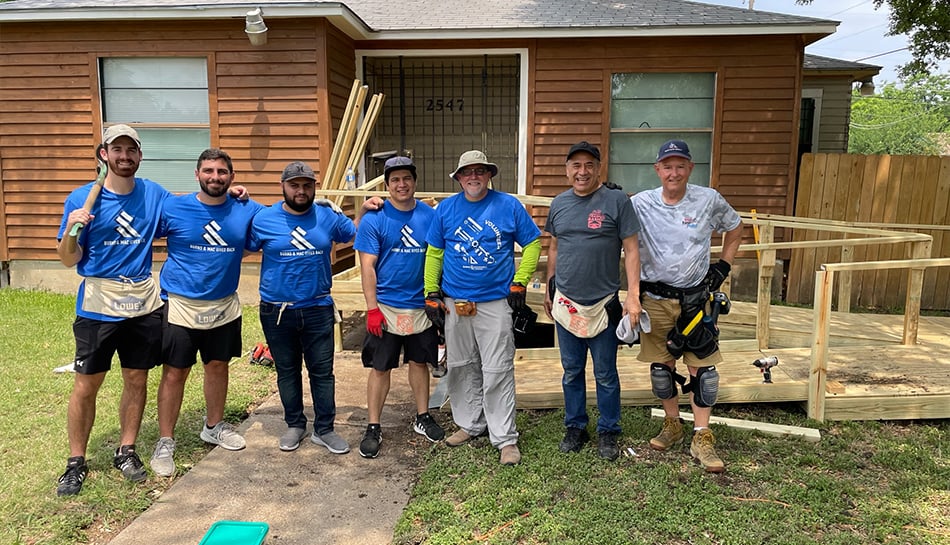 Volunteers posing together in front of house project