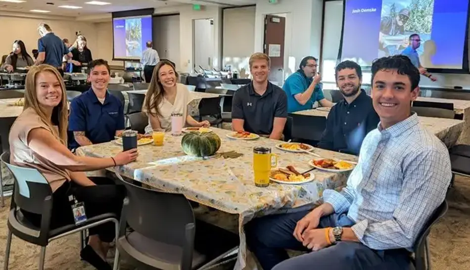 Employee-owners sitting around a table eating pancakes.