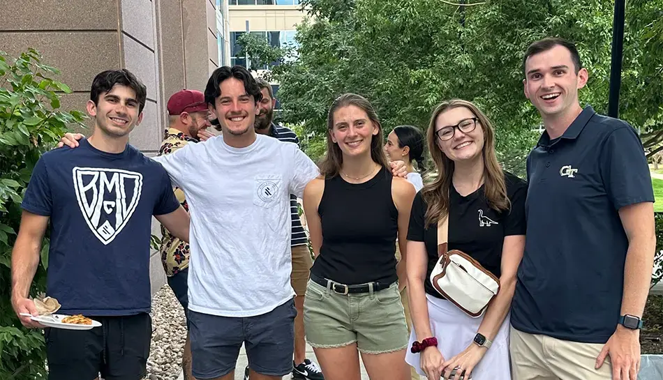 Five employee owners posing at a picnic