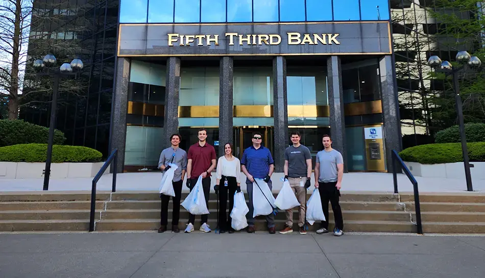 trash collecting team in front of building steps