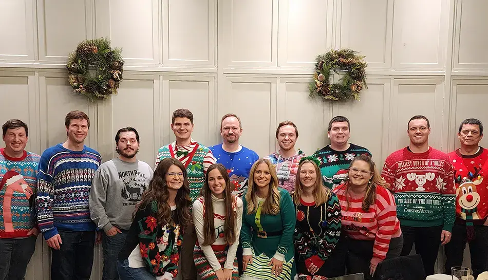 office team poses in holiday sweaters