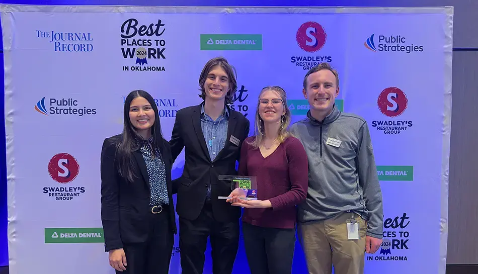 team posing with a best places to work award