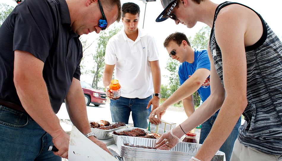 team preps barbecue for event