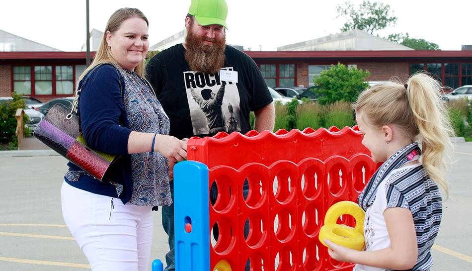 family plays yard game in parking lot