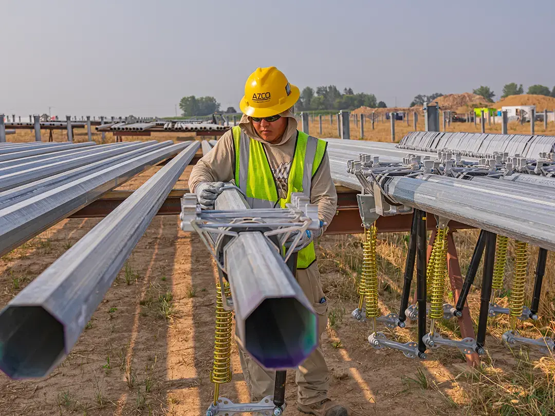 construction worker connects components to poles