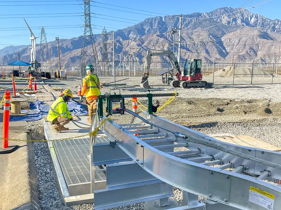 construction underway with wind turbines and mountains in background