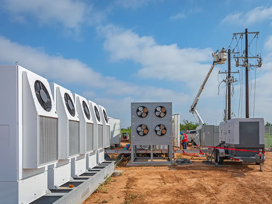 overhead line work next to battery units with cooling fans