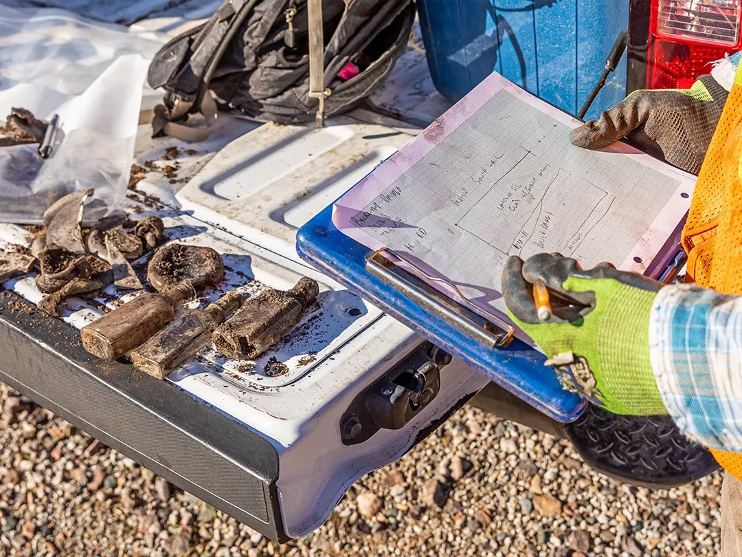 worker records details about historical items found on project site