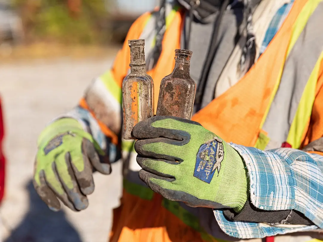 worker holds two bottles found on project site