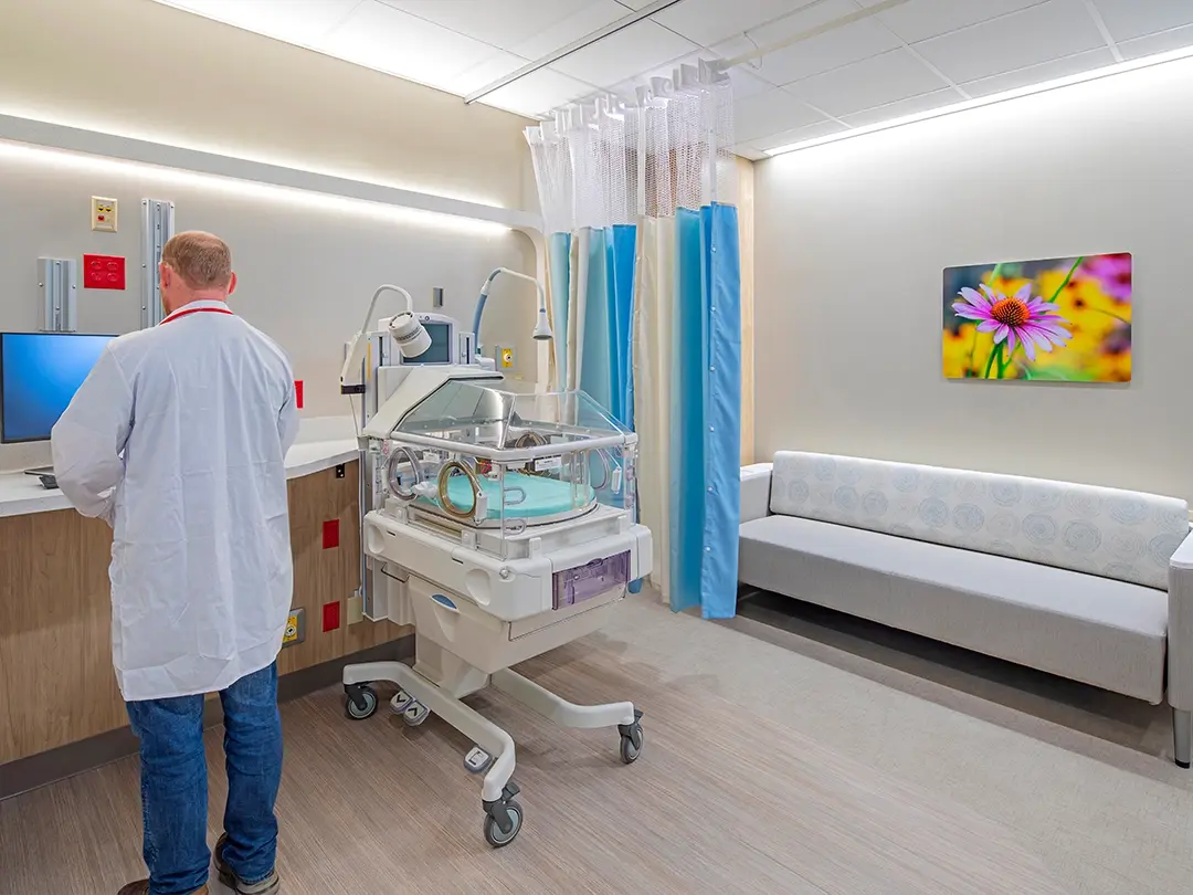 hospital room with couch, colorful artwork, infant monitoring bed