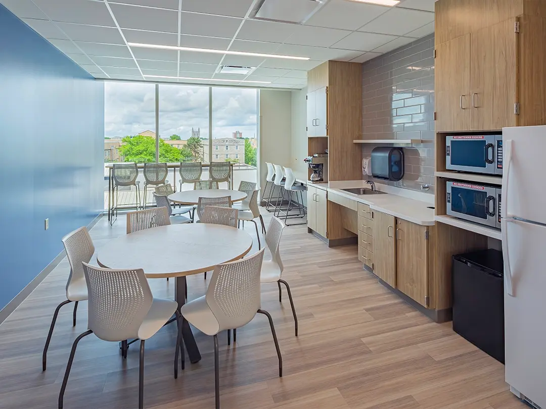 hospital kitchenette with tables, window seating, coffee bar, sink, microwaves and refrigerator