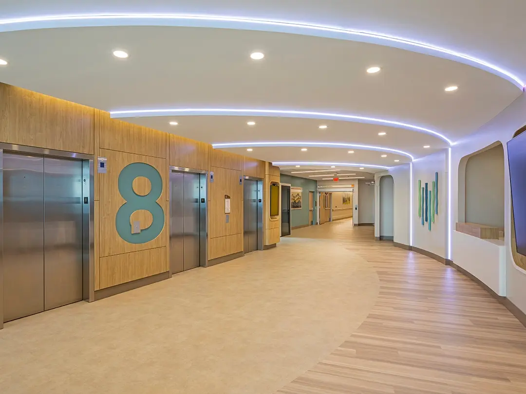 elevator area with perspective down hallway and dramatic ceiling lighting