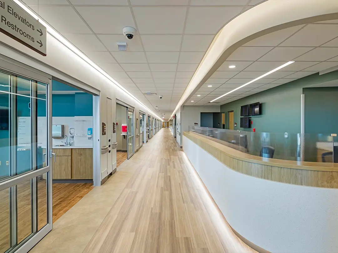 hospital hallway with nurse's station and ceiling/floor lighting