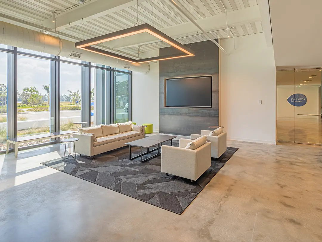 waiting area with couches, coffee table and large screen