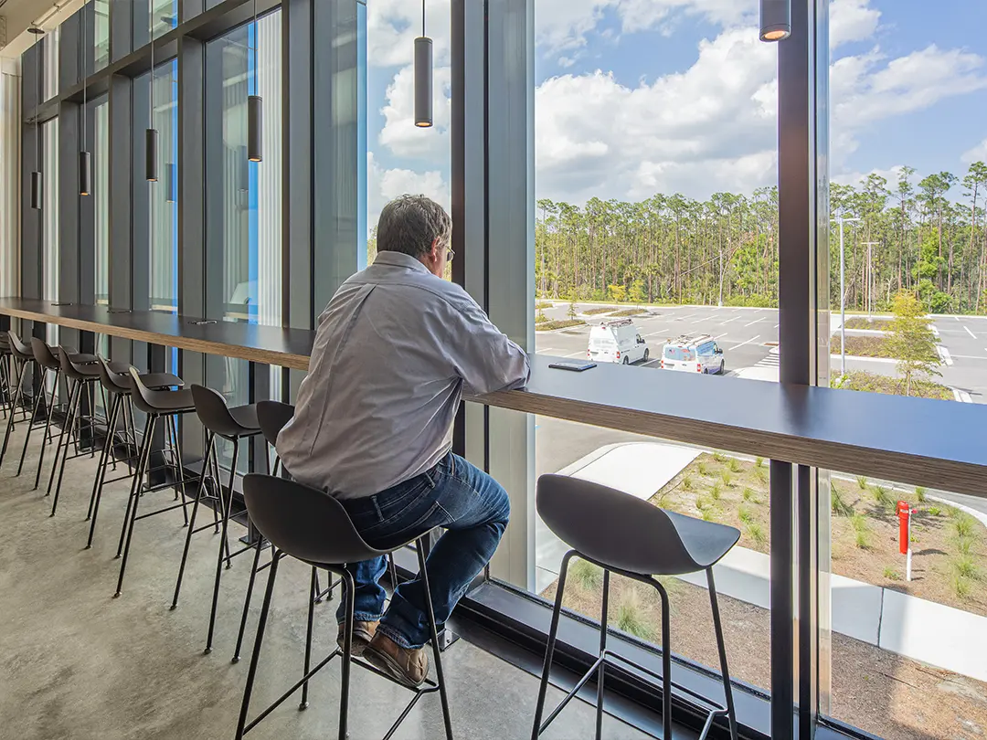 worker at window bar seating on upper floor of building
