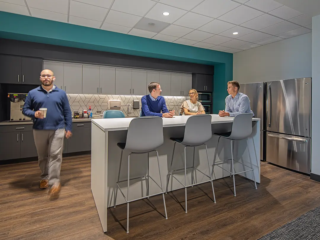 office workers gather in kitchen common area