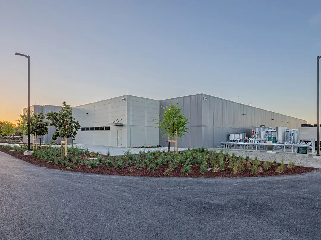 exterior of building with decorative planting area and HVAC equipment