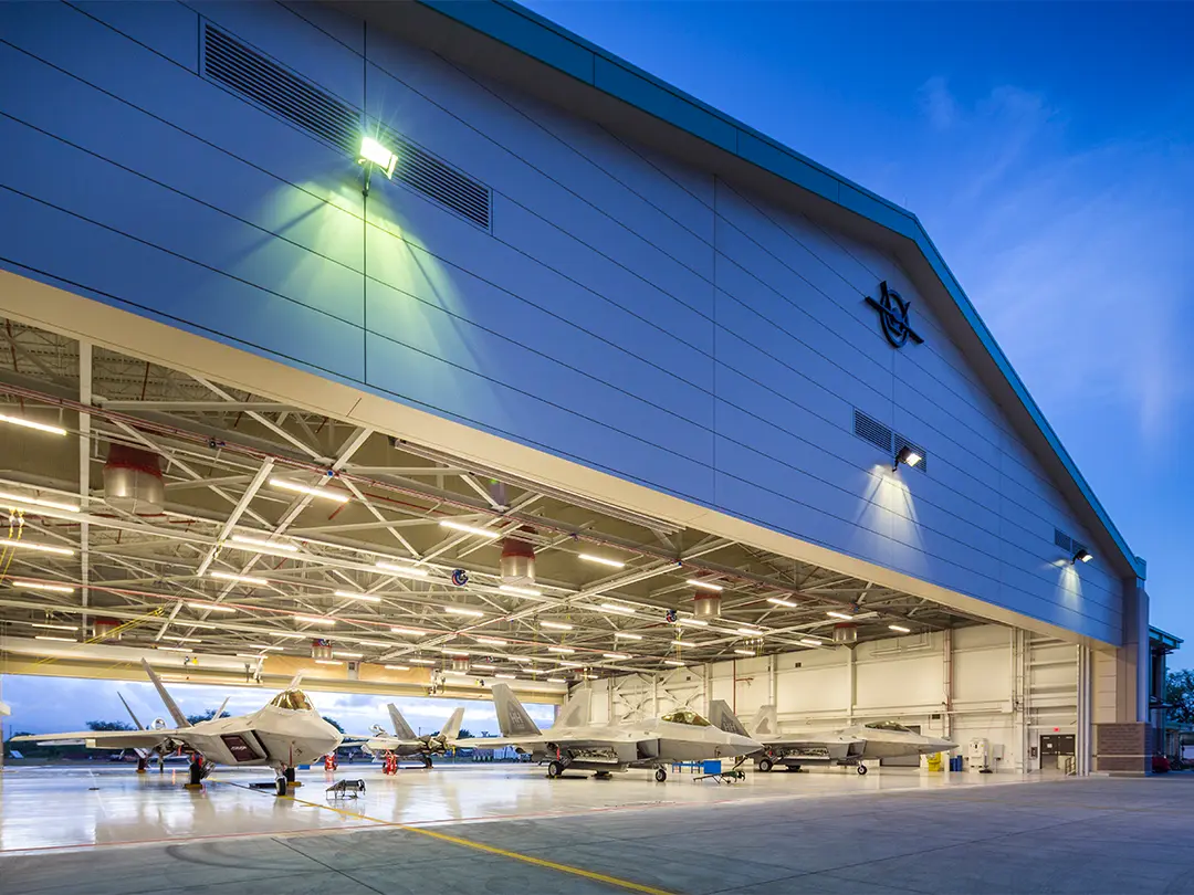 view of military aircraft in hangar at dusk