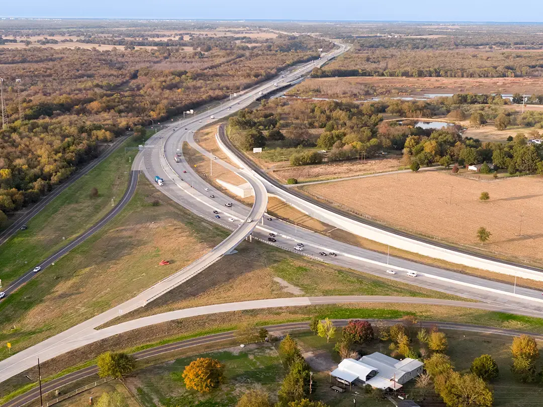 aerial view of highway interchange, including flyover ramp, rail line and highway traffic