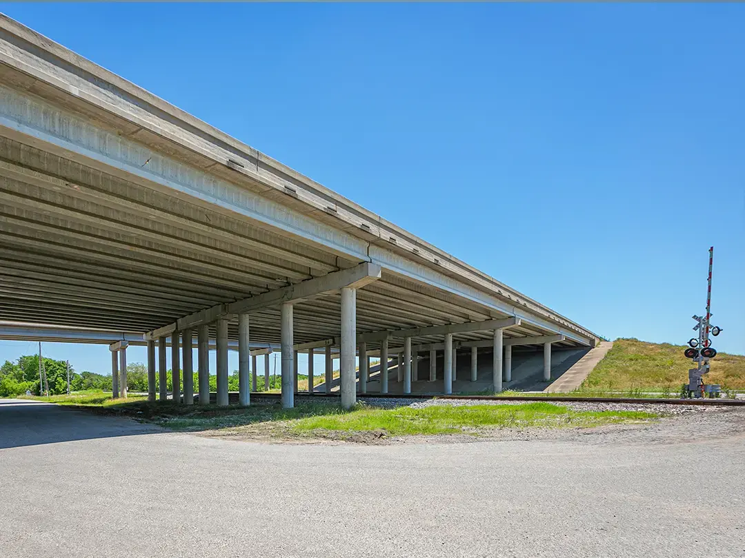 underside view of interstate highway bridge over rail crossing