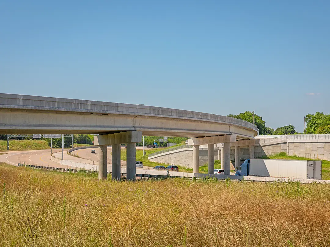 view of traffic beneath highway overpass and adjacent retaining walls