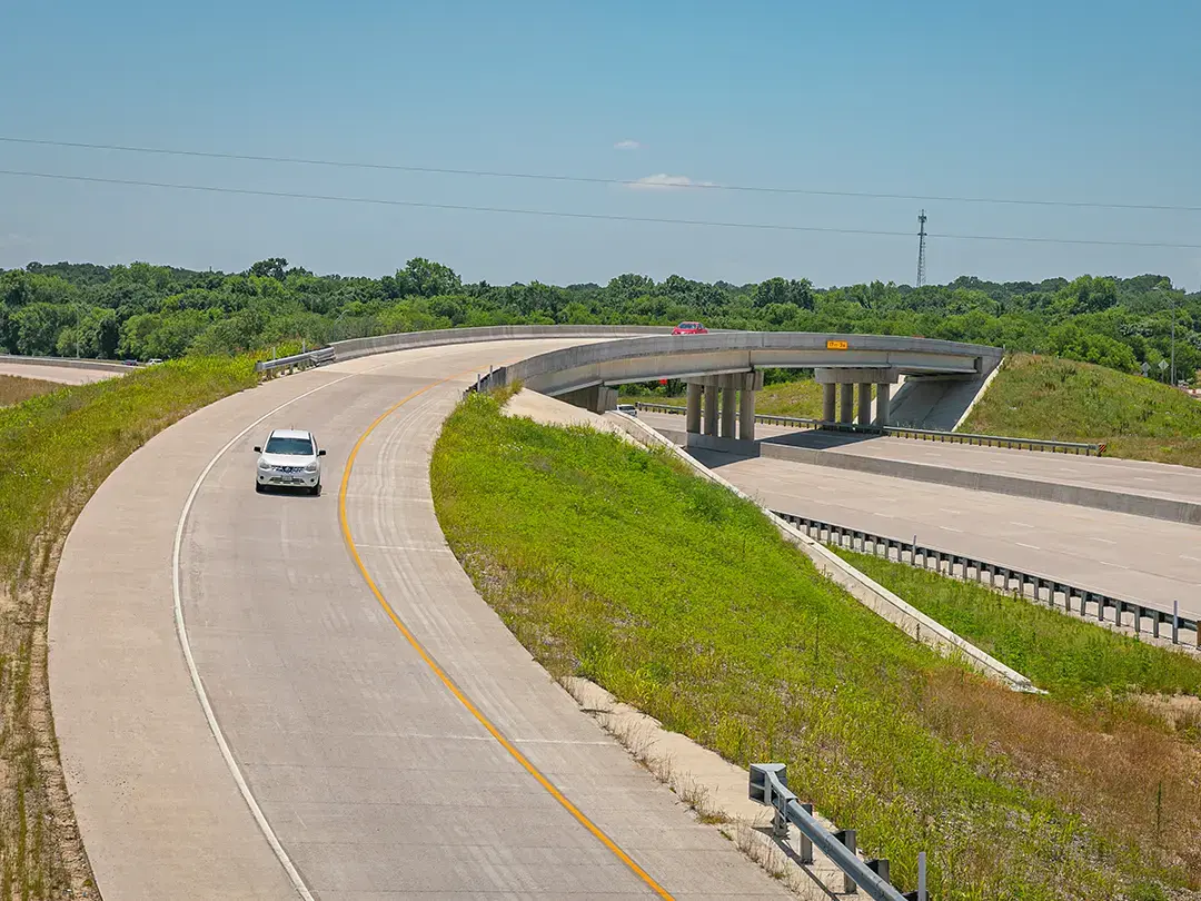 cars driving on overpass bridge over widened interstate highway