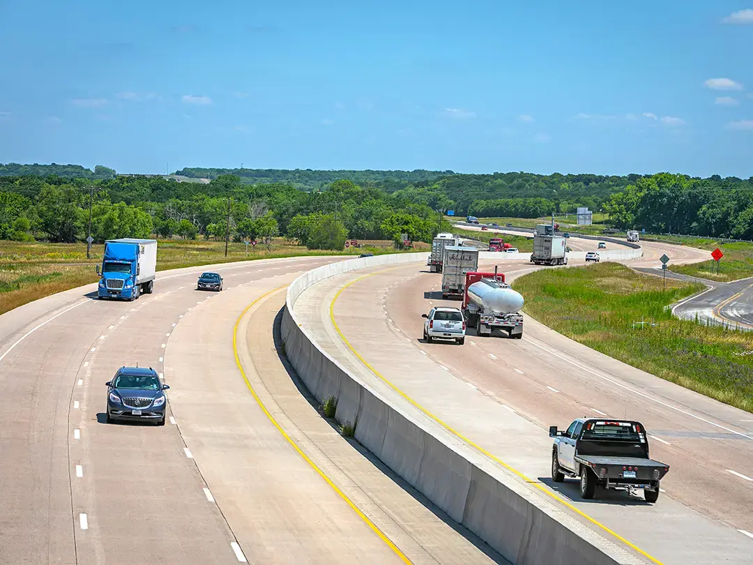 traffic moving around a curve on new, wider interstate highway