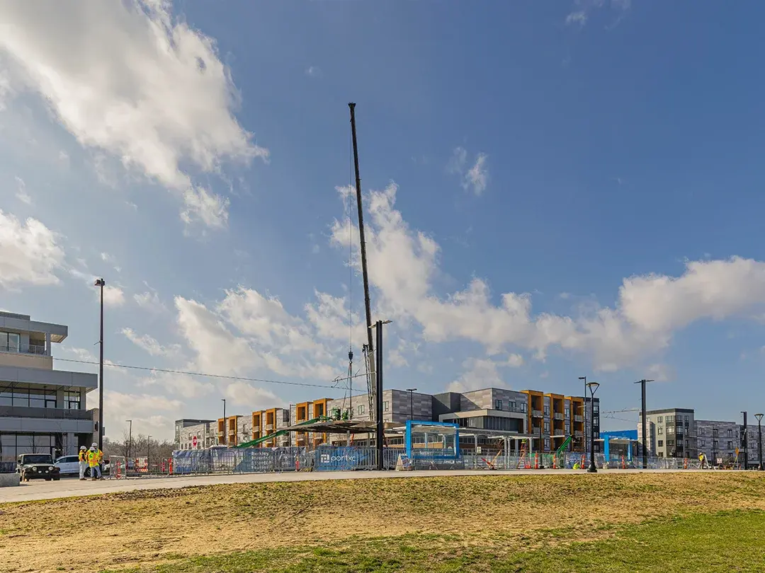 wide view of pavilion roof being set via crane