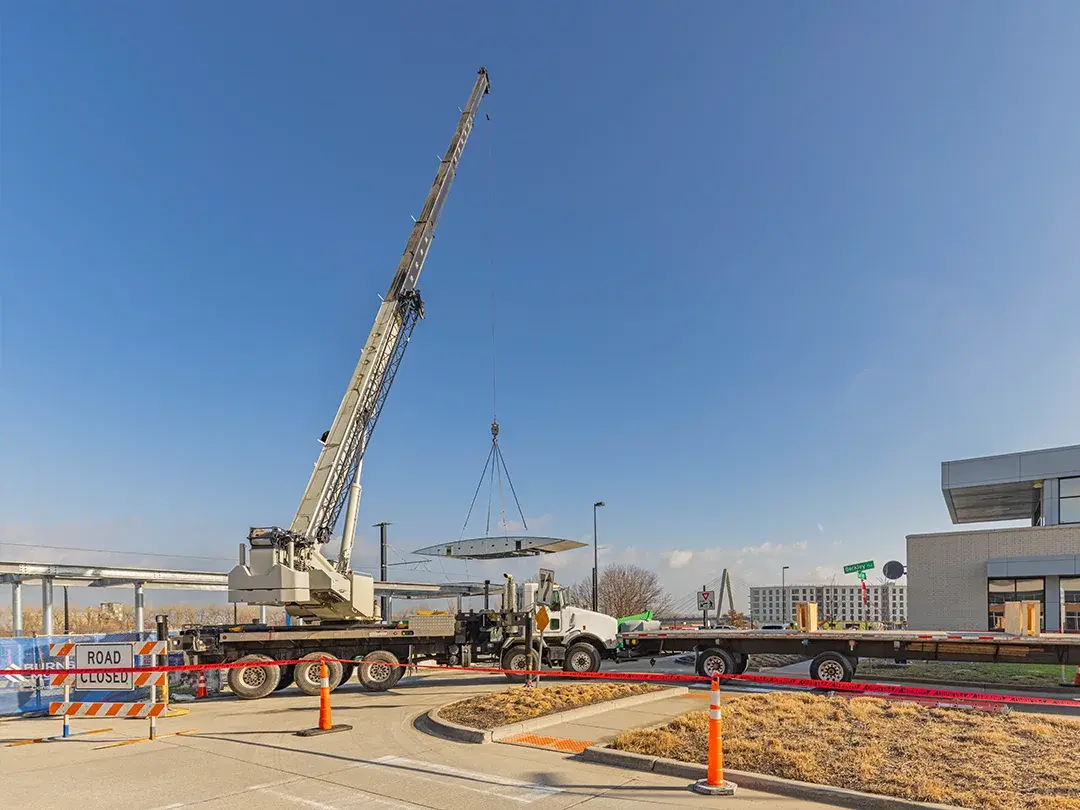 crane lifts component from truck to site