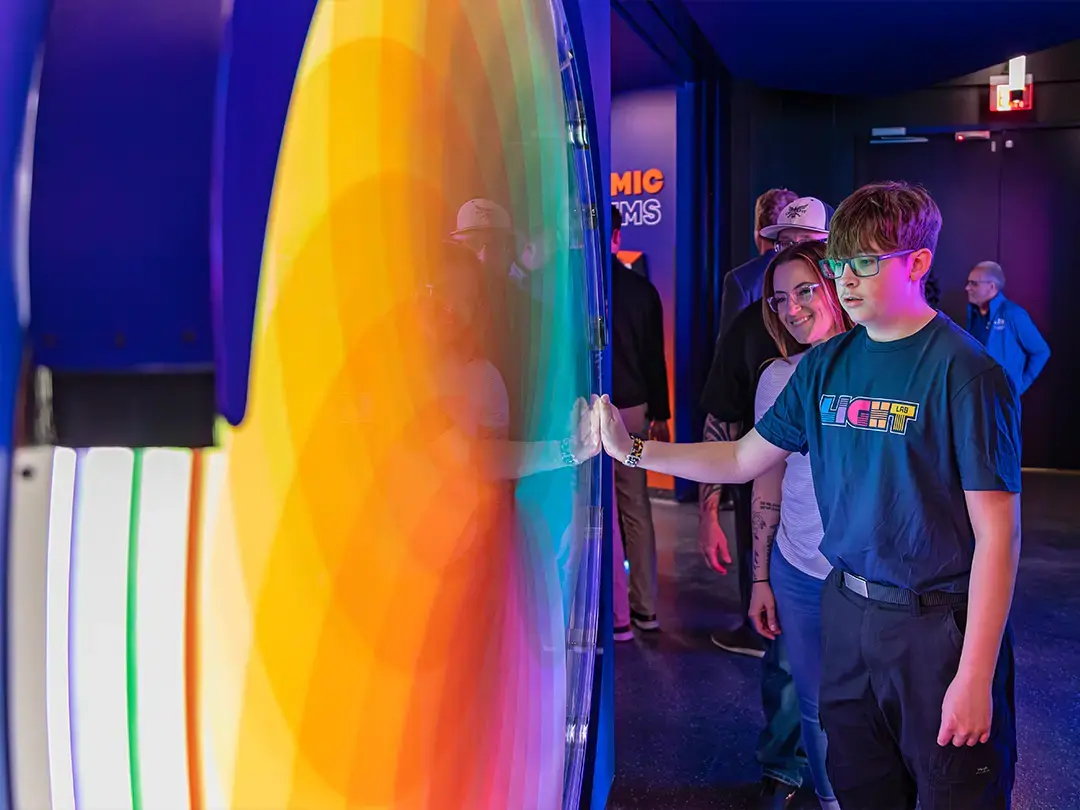 a student explores a large color wheel in the exhibit