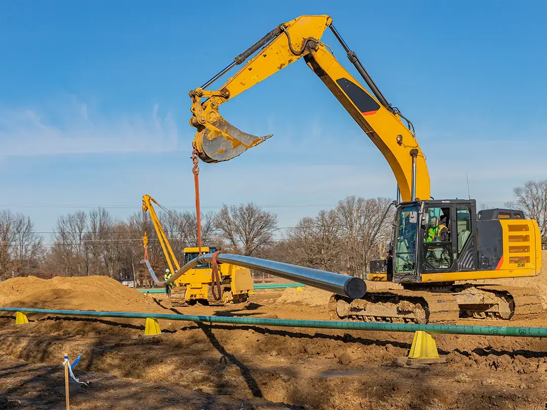 pipe being lifted into place on construction site