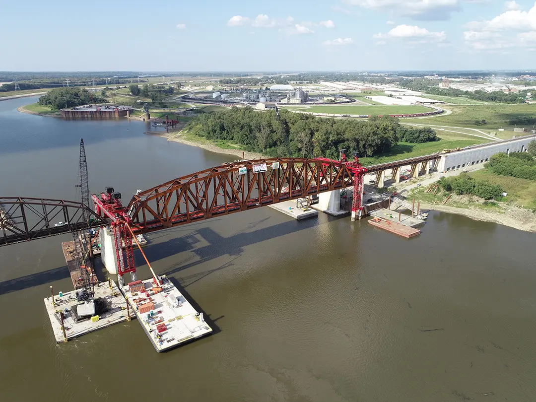 cranes working from barges on the river to construct river-crossing bridge