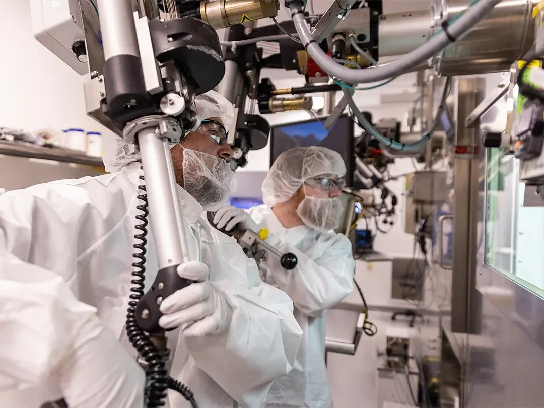 staff members operate equipment wearing clothing covers and hair/beard nets