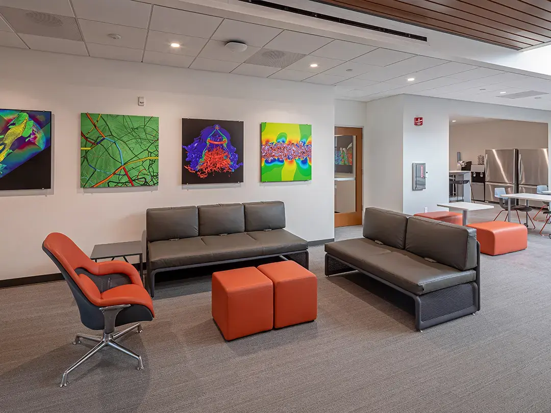 casual seating area with couches and colorful artwork; kitchen and dining areas in background