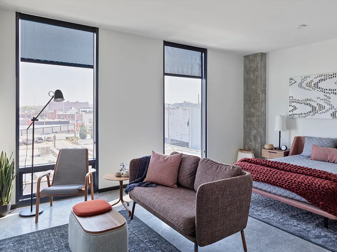 interior view of upper floor studio apartment with sofa, bed, window