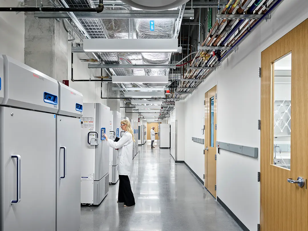 hallway in research facility with workers checking equipment