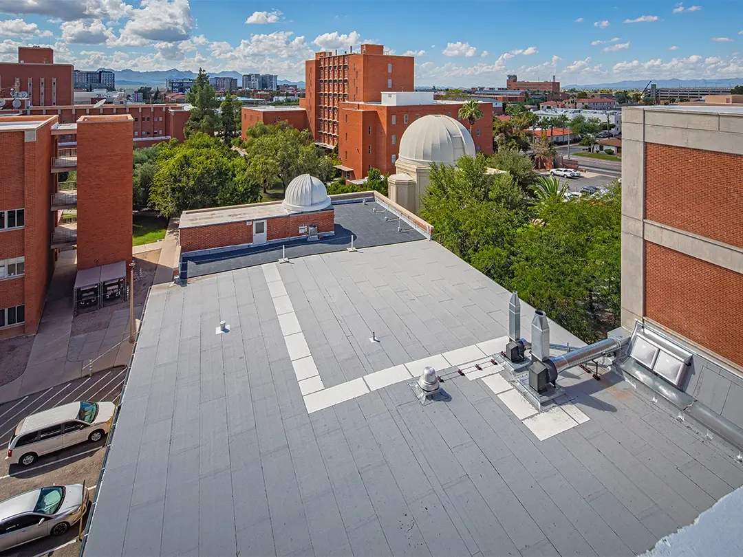 rooftop with observatory domes and city view in background