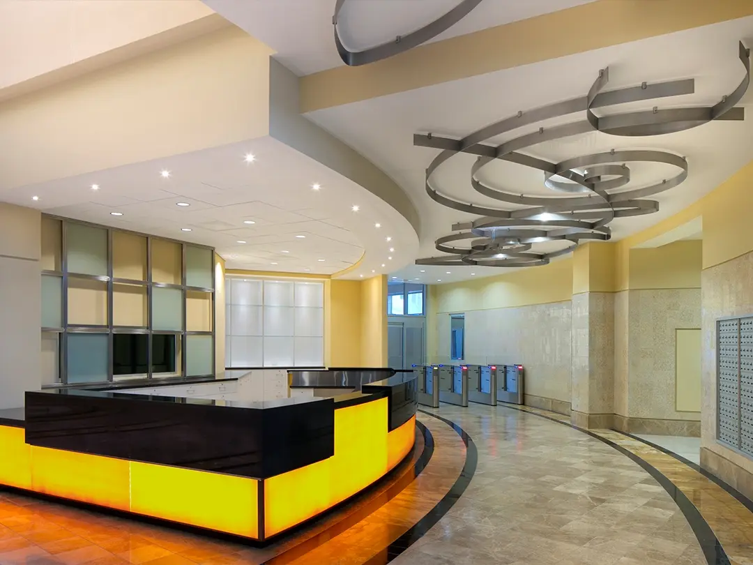 lobby entrance area with reception desk, controlled access turnstiles, mailboxes and sculptural lighting