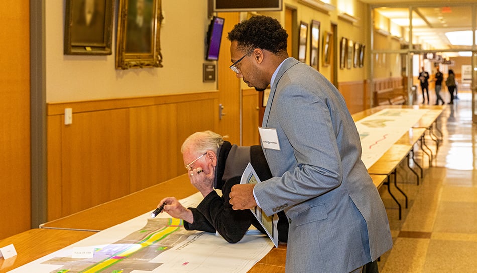 team member and member of public examine project map