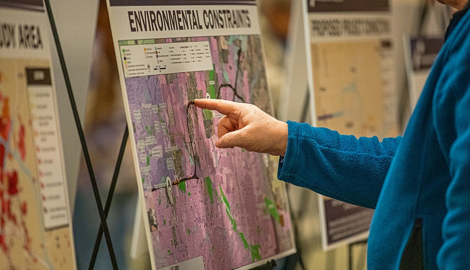 closeup of person's finger pointing to element on environmental constraint map on a sign