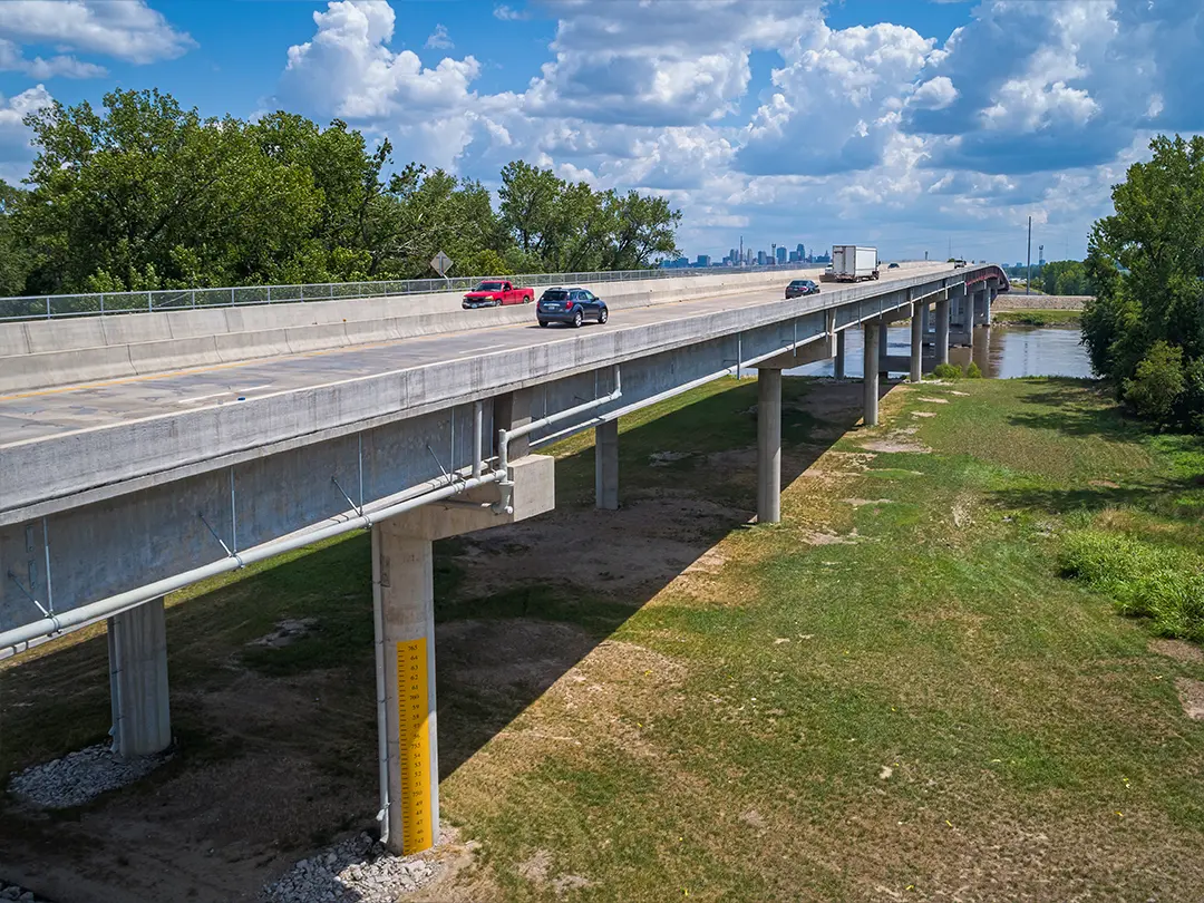 cars on ramp to bridge crossing river