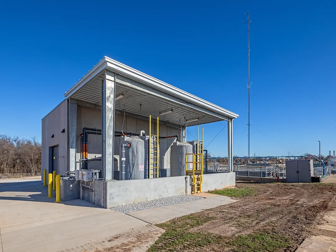 exterior building view with storage tanks and treatment basins in background