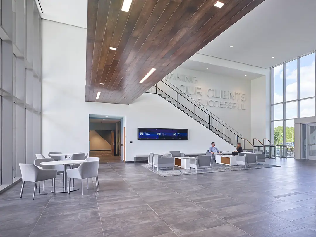 branded lobby area with seating, collaboration tables, branded messaging and electronic displays