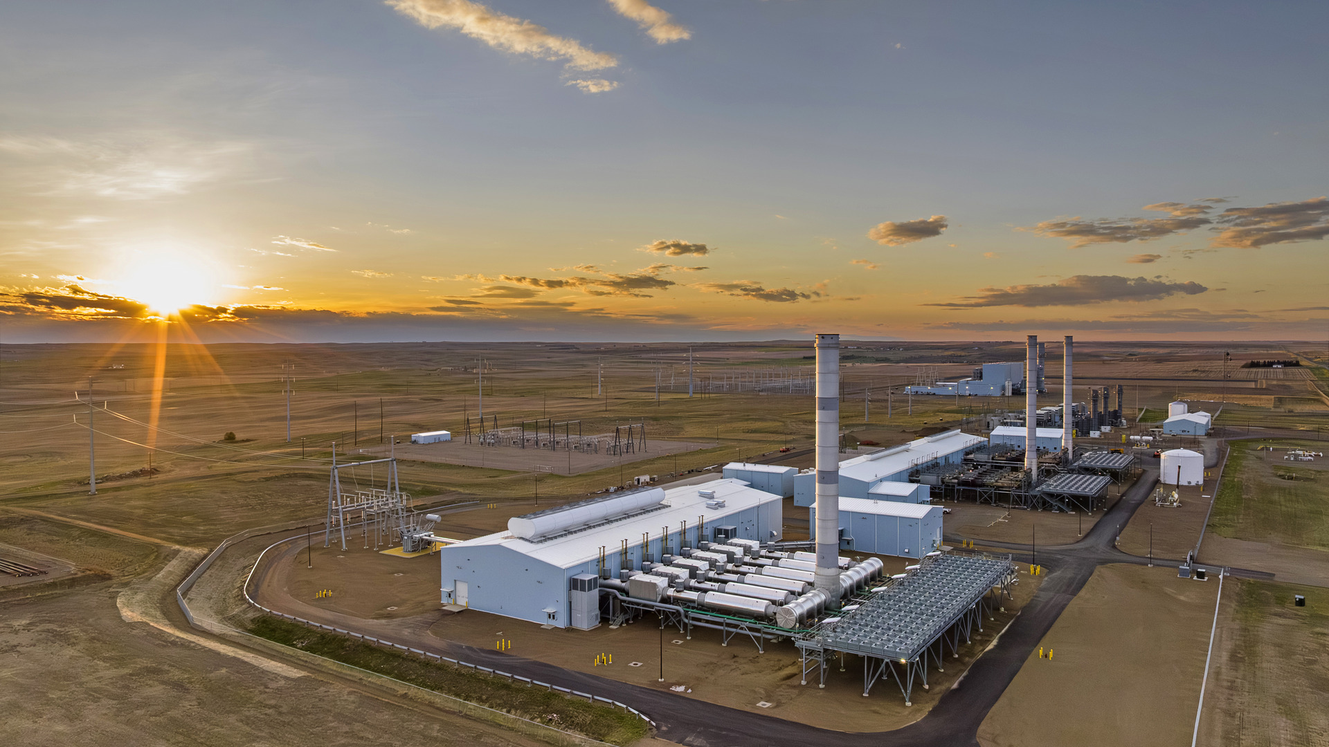 Power generation facility with cooling equipment, transmission infrastructure and tall stacks.