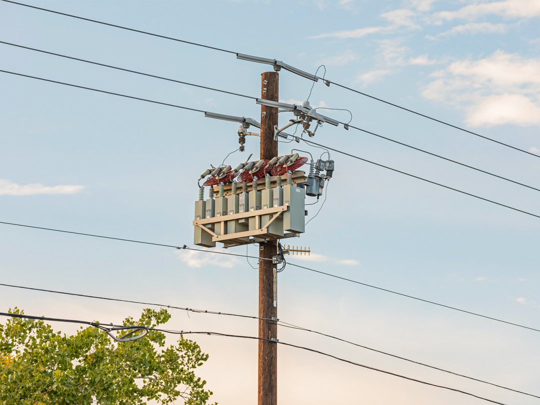 view of equipment atop a wooden power distribution pole